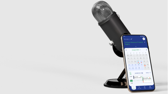 Mikrofon na stojaku z opartym smartfonem, wyświetlonym kalendarzem.